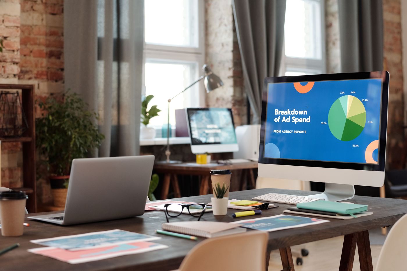 A studio desk with a large display showing a campaign performance dashboard
